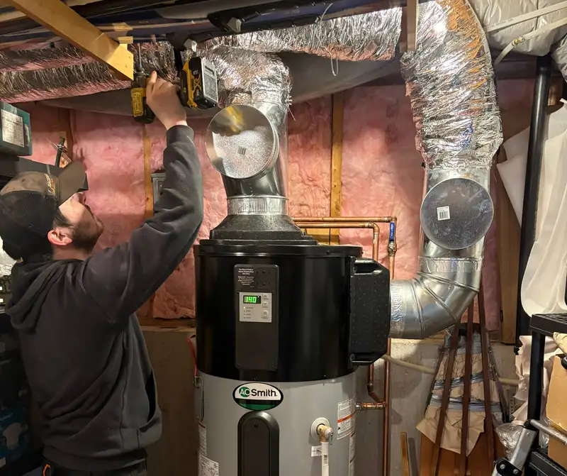 Technician servicing a residential water heater system.